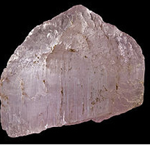 kunzite rough coming out of ground with dirt on it