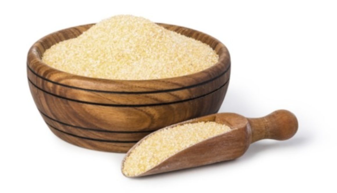 A wooden bowl and scoop filled with yellow cornmeal